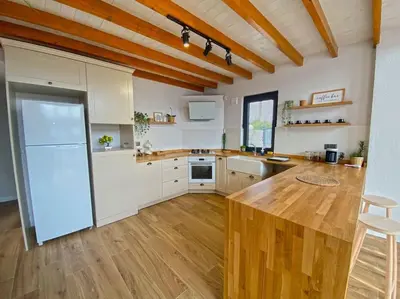 a large kitchen with a wooden counter and a refrigerator at Sapanca İnci Suit in Yanık