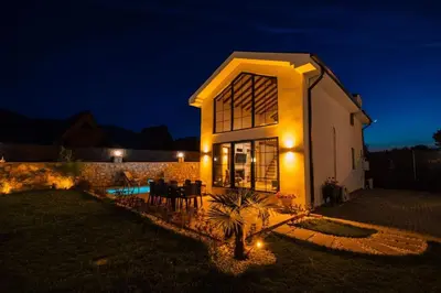 a house with lights on the side of it at night at Sapanca İnci Suit in Yanık