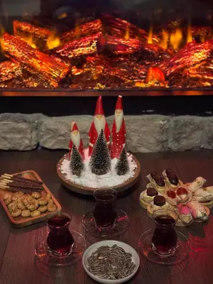 a table with food and wine glasses and a fireplace at THEA Sapanca Bungalov in Dilekli
