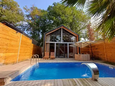 a swimming pool in front of a house at THEA Sapanca Bungalov in Dilekli