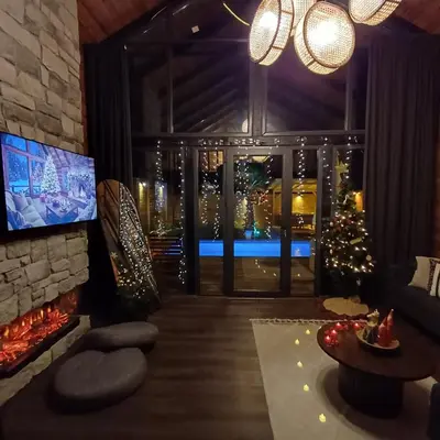 a living room with a fireplace and a christmas tree at THEA Sapanca Bungalov in Dilekli