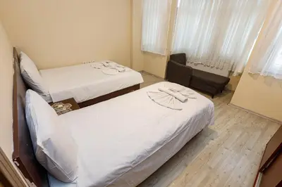 a room with two beds and a chair at Marmara Apartments in Istanbul
