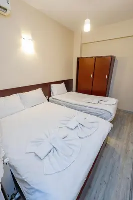 two beds in a room with white sheets at Marmara Apartments in Istanbul