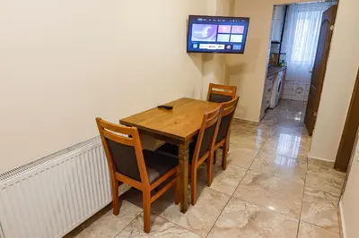 a dining room table and chairs with a television on the wall at Marmara Apartments in Istanbul