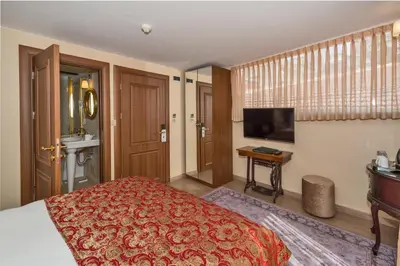 a bedroom with a bed and a flat screen tv at By Murat Royal Hotel Galata in Istanbul