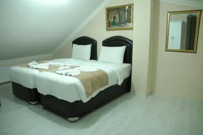 a bedroom with a large bed with white sheets at Tolga Hotel in Istanbul