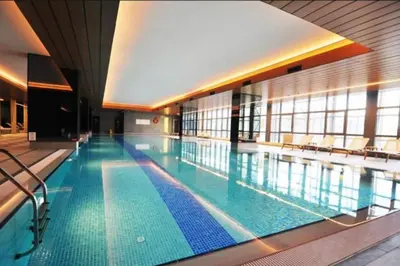a large swimming pool with chairs in a building at Cozy luxury apt in Sinpas queen in Istanbul
