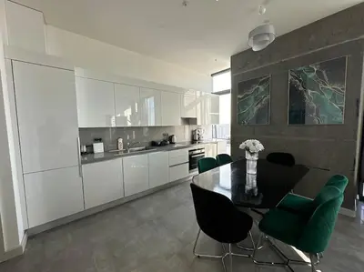 a kitchen with a dining table and green chairs at Elegant 2 bedroom apt Sinpas queen gym pools in Istanbul