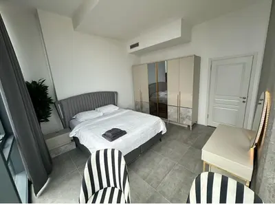 a small bedroom with a bed and two chairs at Elegant 2 bedroom apt Sinpas queen gym pools in Istanbul