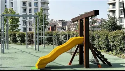 a playground with a yellow slide in a park at Luxury apt in the 40 plus floor in Istanbul