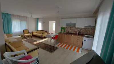a room with a kitchen and a living room at Kadıoğlu Pansiyon in Ormanlı