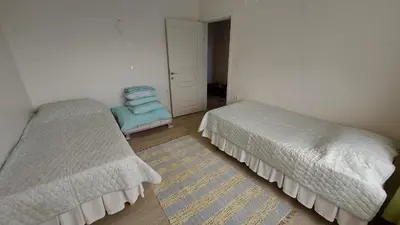 a bedroom with two beds and a rug at Kadıoğlu Pansiyon in Ormanlı
