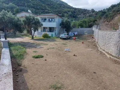 a bird standing in the dirt in front of a house at Kadıoğlu Pansiyon in Ormanlı