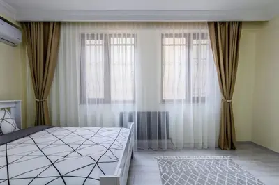 a bedroom with a large bed and two windows at Fatih'te yeni 3 odalı Daire No 1 in Istanbul