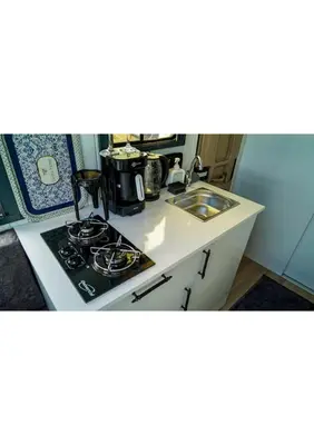 a kitchen with a stove and a sink at HUZURLU BİR TATİl - CARAVAN SERENITY in Domalı