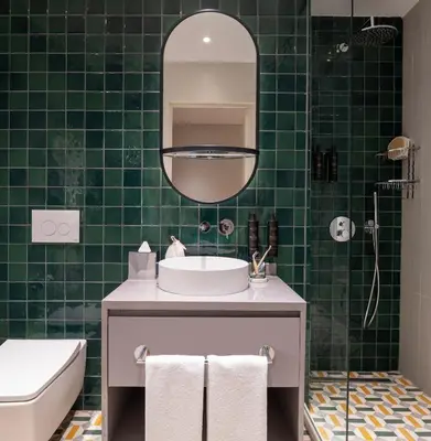 a green tiled bathroom with a sink and a mirror at Casa Foscolo Hotel, Istanbul, a Member of Design Hotels in Istanbul
