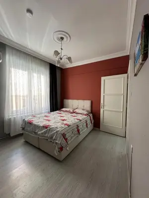 a bedroom with a bed and a red wall at Bursa central house in Bursa