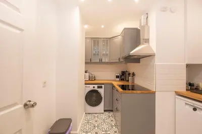 a small white kitchen with a washer and dryer at Trendy Waterfront Apt with a Striking View in Istanbul