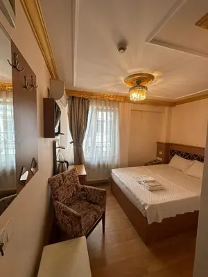 a hotel room with a bed and a chair at Delbab PANSİYON in Istanbul