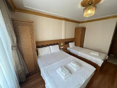 a bedroom with two beds and a chandelier at Delbab PANSİYON in Istanbul