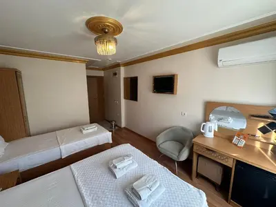 a hotel room with two beds and a desk at Delbab PANSİYON in Istanbul
