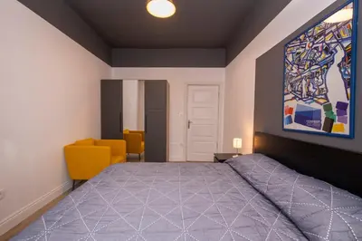 a bedroom with a bed and a yellow chair at Hip Waterfront Apt with a Striking View in Istanbul