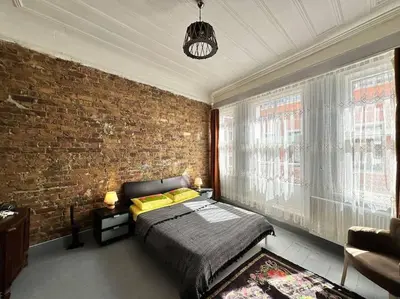 a bedroom with a bed and a brick wall at Yildirim's Home in Istanbul