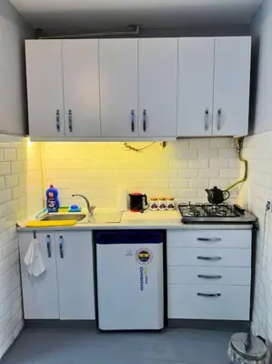 a small kitchen with white cabinets and a sink at Yildirim's Home in Istanbul