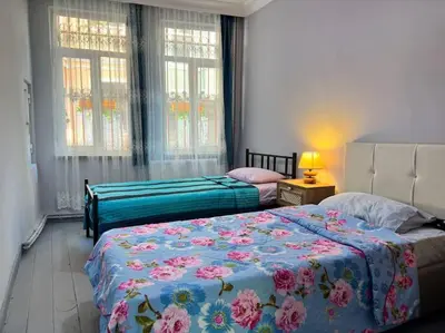 a bedroom with two beds and two windows at Yildirim's Home in Istanbul