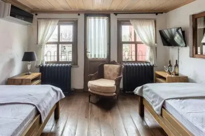 a bedroom with two beds and a chair and a tv at Balat luxury House With Sea View in Istanbul