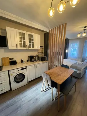 a kitchen with white cabinets and a wooden table at Golden Arrow Taksim 1 in Istanbul