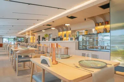 a restaurant with wooden tables and chairs and yellow cabinets at Romatem Move İstanbul Disabled Hotel in Istanbul