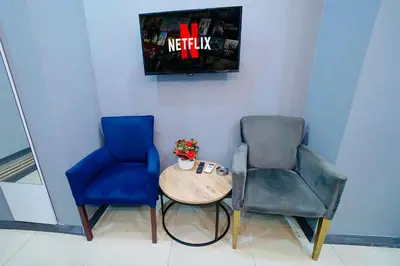 a room with two chairs and a table and a tv at Cevas Suite Hotel in Istanbul