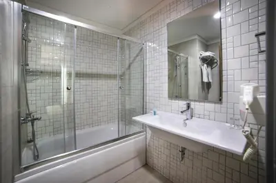 a bathroom with a tub and a sink and a shower at Plus Hotel Bostanci Atasehir in Istanbul