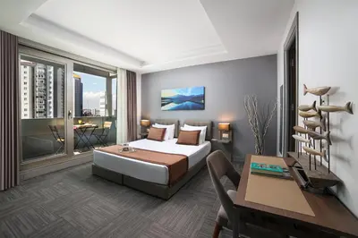 a bedroom with a bed and a table and a desk at Plus Hotel Bostanci Atasehir in Istanbul