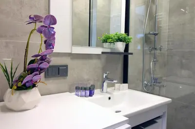 a bathroom with a sink and a vase with purple flowers at Excellent Apartments Fatih Golden Horn in Istanbul