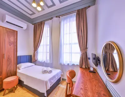 a small room with a bed and a mirror at Va Mansion in Istanbul