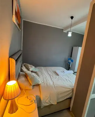 a small bedroom with a bed and a lamp at Cosy studio apartment in Istiklal central in Istanbul