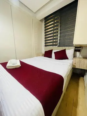 a bedroom with a large white bed with red pillows at Taksim Gold House Hotel in Istanbul