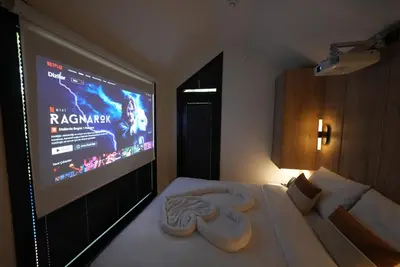 a hotel room with a large projection screen on a bed at Saklı Vadi Tiny House in Masukiye