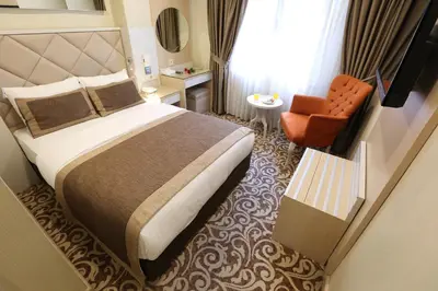 a hotel room with a bed and a chair at Alpinn Hotel Istanbul in Istanbul