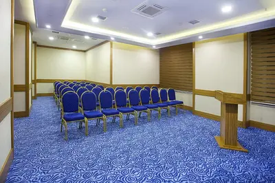 a conference room with blue chairs and a podium at Alpinn Hotel Istanbul in Istanbul