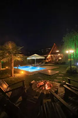 a swimming pool at night with chairs and a table at Resort Mola Sapanca in Sapanca