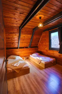 two beds in a wooden room with a window at Resort Mola Sapanca in Sapanca