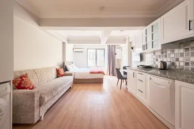 a living room with a couch and a kitchen at aymira hotel pangaltı in Istanbul