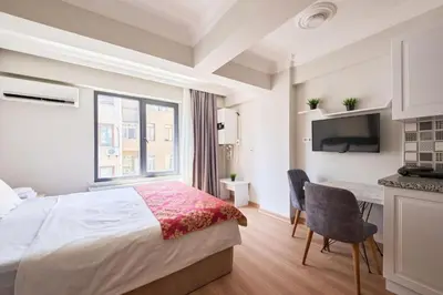 a bedroom with a bed and a desk and a tv at aymira hotel pangaltı in Istanbul