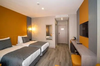 a hotel room with two beds and a flat screen tv at Icon Hotel Bomonti in Istanbul