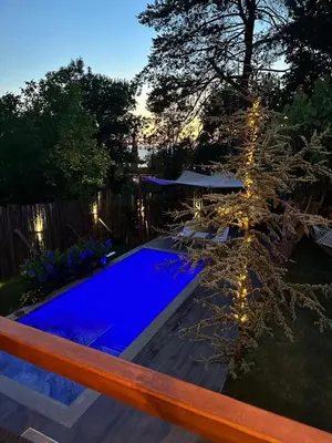 a backyard with a blue swimming pool and a tree at Efe Köy Evi in Sapanca