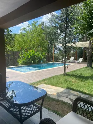 a patio with a table and a swimming pool at Efe Köy Evi in Sapanca