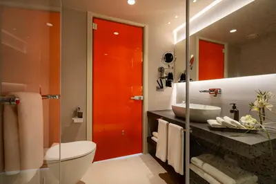 a bathroom with a toilet and a sink and a red door at ERK Hotel in Istanbul